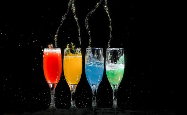 a group of glasses with different colored drinks